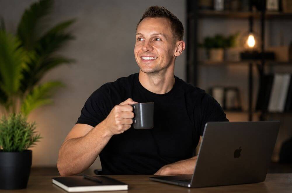 Mark with a coffee beside his laptop